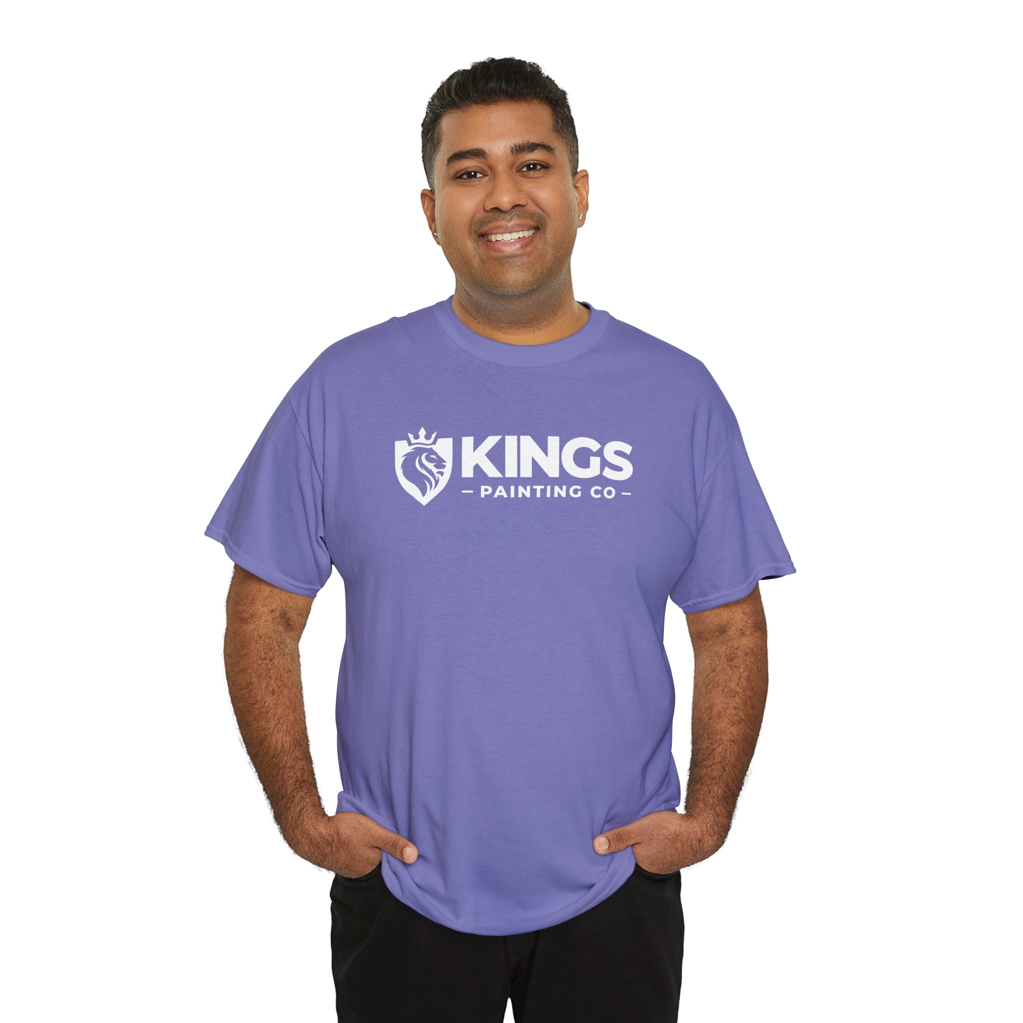 A smiling person with short dark hair is wearing the Kings Painting Co. Logo T‑Shirt (Classic) | Gildan Ultra Cotton (G5000) in purple, standing with hands in pockets against a white background.