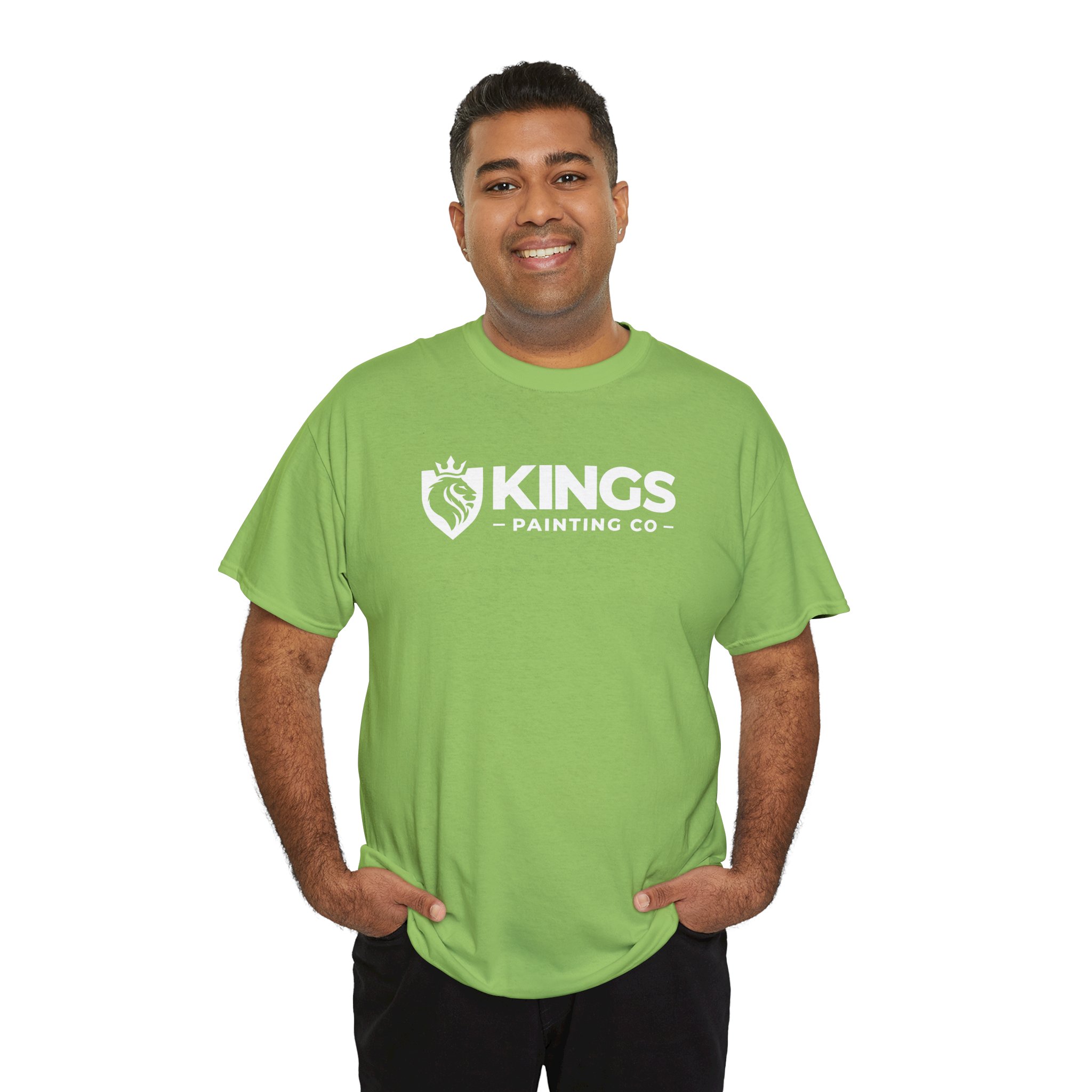 A man smiles while wearing a light green Kings Painting Co. Logo T‑Shirt (Classic) | Gildan Ultra Cotton (G5000), standing against a plain white background with his hands in his pockets.