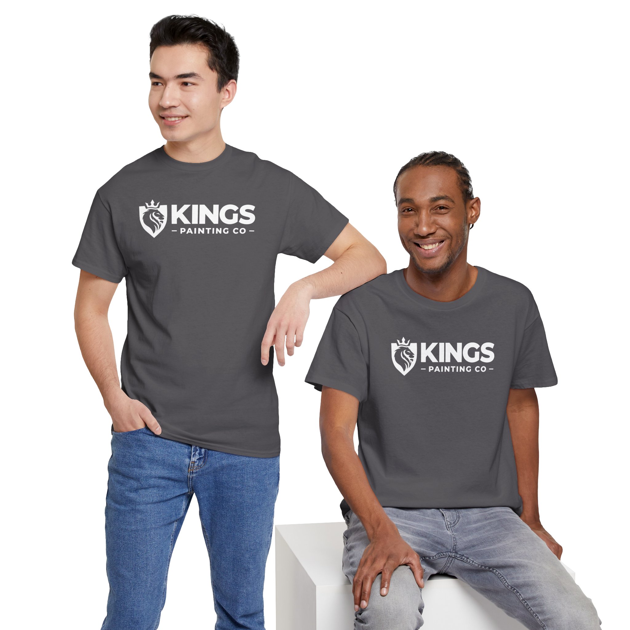 Two men, both smiling and facing the camera, wear matching Kings Painting Co. Logo T‑Shirts (Classic) made from Gildan Ultra Cotton (G5000). One stands with his hand in his pocket while the other is seated on a white block, all set against a plain white background.